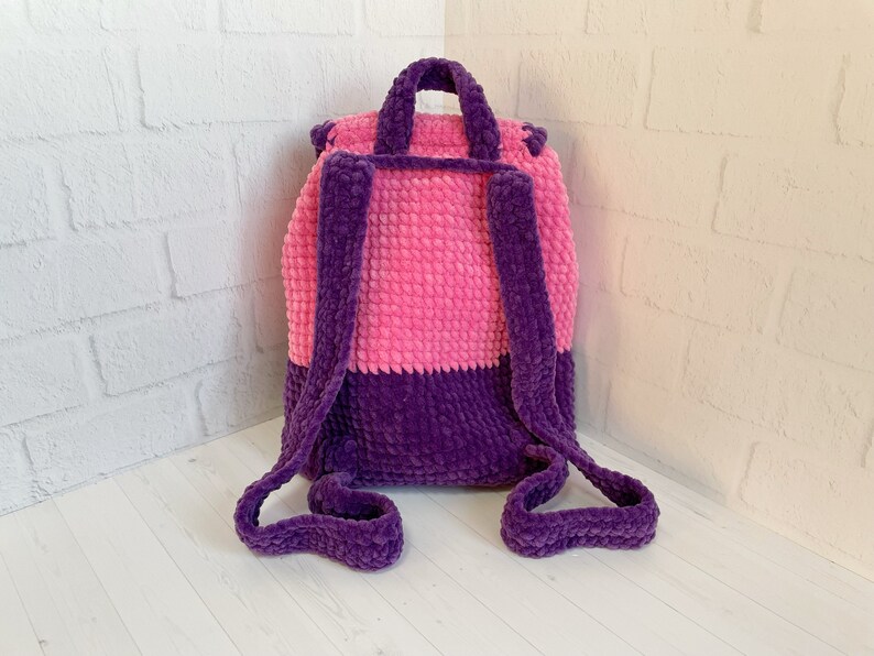 Pu&ograve; includere: Uno zaino in crochet rosa e viola con spalline regolabili. Lo zaino &egrave; realizzato con un filato morbido e soffice.