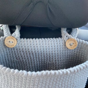 May include: Gray crocheted hanging organizer with two wooden buttons that say "Handmade with love".