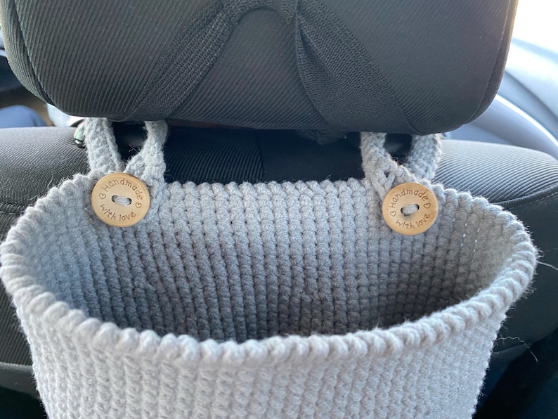 May include: Gray crocheted hanging organizer with two wooden buttons that say "Handmade with love".