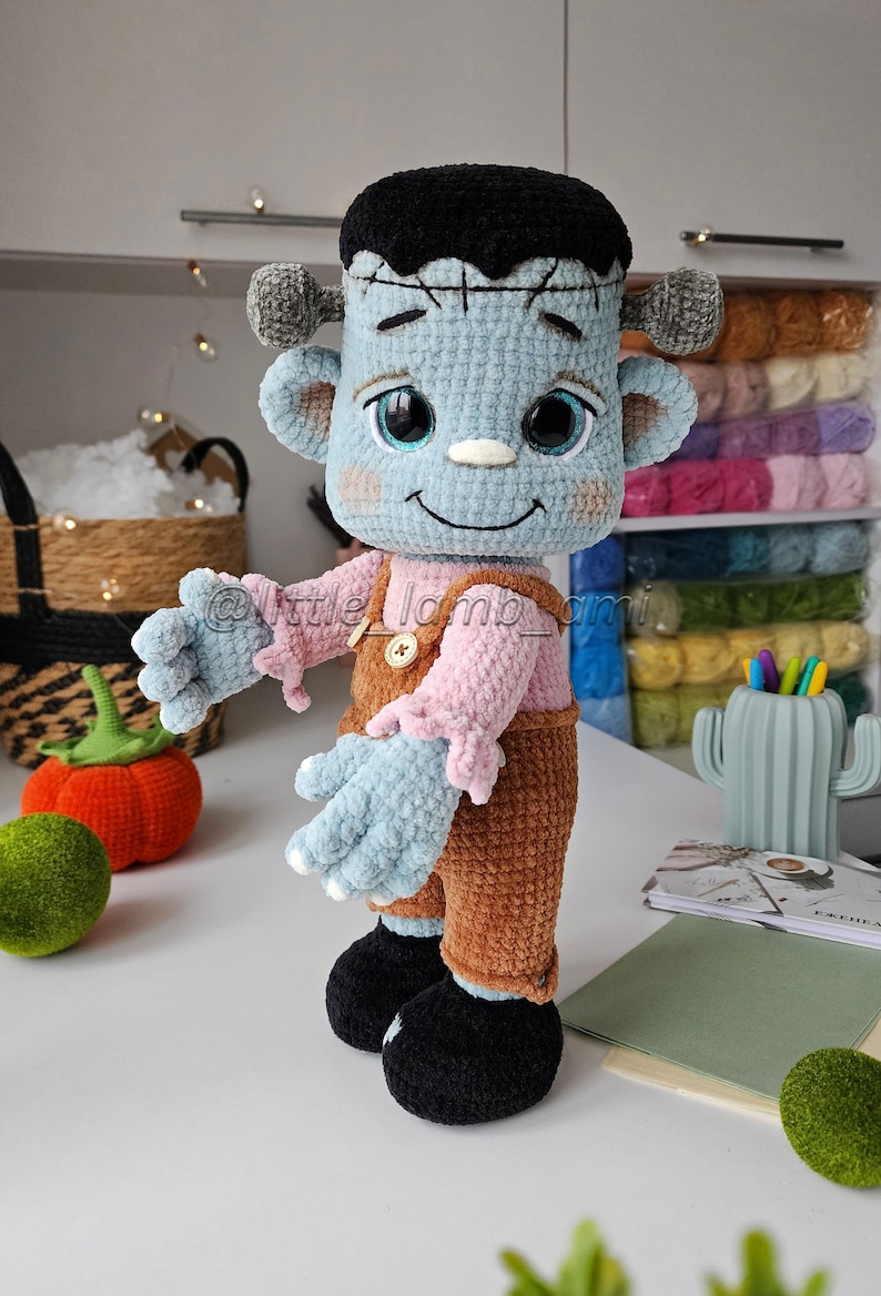 Soft crochet Frankenstein toy made with velvet yarn, wearing brown overalls and a pink shirt. Crochet pattern for beginners and intermediates, detailed and easy to follow.