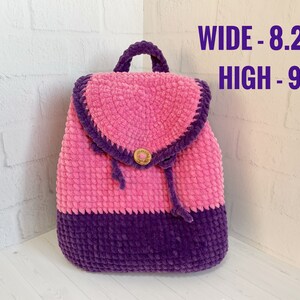 Pu&ograve; includere: Uno zaino in crochet rosa e viola con chiusura a bottone. Lo zaino misura 8,2 pollici di larghezza e 9,4 pollici di altezza. LARGHEZZA - 8,2" ALTEZZA - 9,4"