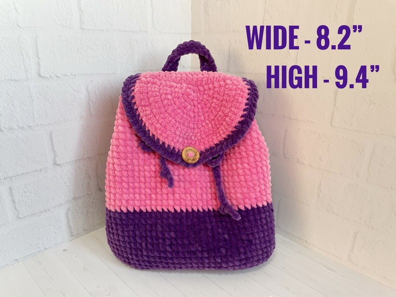 Pu&ograve; includere: Uno zaino in crochet rosa e viola con chiusura a bottone. Lo zaino misura 8,2 pollici di larghezza e 9,4 pollici di altezza. LARGHEZZA - 8,2" ALTEZZA - 9,4"