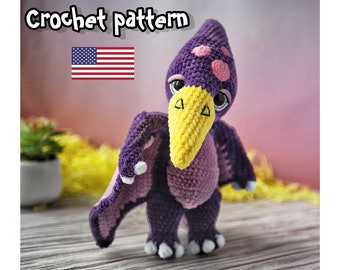 May include: Crochet pattern for a purple and pink pterodactyl amigurumi toy with yellow beak and white claws. The pattern is available in US English.