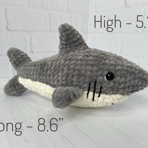 Puede incluir: Juguete de peluche de tibur&oacute;n gris tejido a crochet con vientre blanco y ojos negros. El juguete mide 5,1 pulgadas de alto y 8,6 pulgadas de largo.