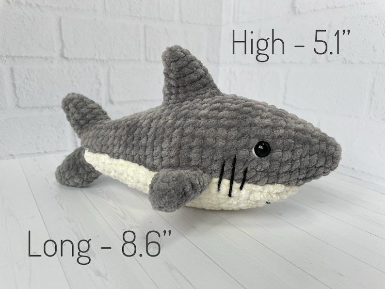 Puede incluir: Juguete de peluche de tibur&oacute;n gris tejido a crochet con vientre blanco y ojos negros. El juguete mide 5,1 pulgadas de alto y 8,6 pulgadas de largo.
