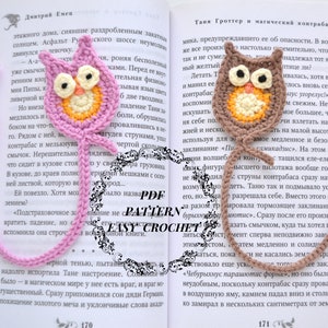 May include: Two crocheted owl bookmarks, one pink and one brown, with a tassel on each. The owls have orange beaks and yellow eyes. The bookmarks are placed on open books with text.
