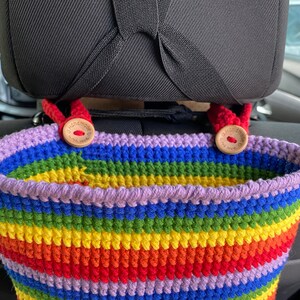 May include: A rainbow crocheted car seat organizer with two wooden buttons that say "Handmade with Love".
