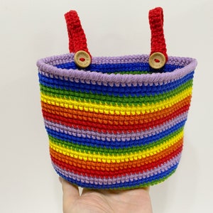 May include: A rainbow striped crocheted basket with red handles and wooden button accents.