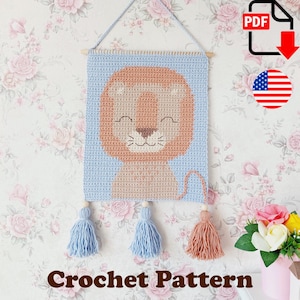 May include: Crochet pattern for a lion wall hanging. The lion is light brown with a blue background. The wall hanging has three tassels in light blue and peach. The text "Crochet Pattern" is at the bottom.