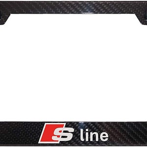 May include: Black carbon fiber license plate frame with the text "S line" in white and red. The frame has a textured appearance and includes two black mounting caps.