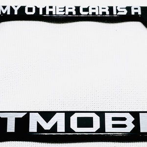 Puede incluir: Marco de matrícula negro con letras plateadas que dicen "My other car is a Batmobile".