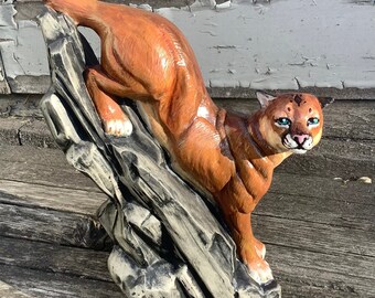 Pumapuma, der unten auf Felsen figurine Statue klettert