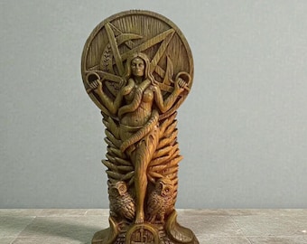 Puede incluir: Una estatua de madera detallada que presenta una figura femenina con una serpiente enrollada alrededor de ella. La estatua tiene un fondo circular con una estrella y otros símbolos. Dos búhos están en la base de la estatua.