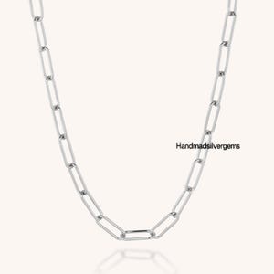 May include: A silver-colored chain necklace with elongated rectangular links. The necklace is displayed against a light background. The text "Handmadsilvergems" is visible on the right side of the image.