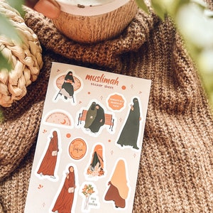 May include: A sticker sheet with illustrations of women wearing hijabs. The sheet includes the text "muslimah sticker sheet", "MODESTY IS A BRANCH OF FAITH", "taqwa", and "DUA & SHUKR".