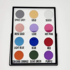 May include: A framed color chart featuring twelve different colors. The colors include space grey, gold, silver, rose gold, lilac, hot pink, light blue, blue, red, cayenne orange, olive green, and purple. Each color is labeled with its name.