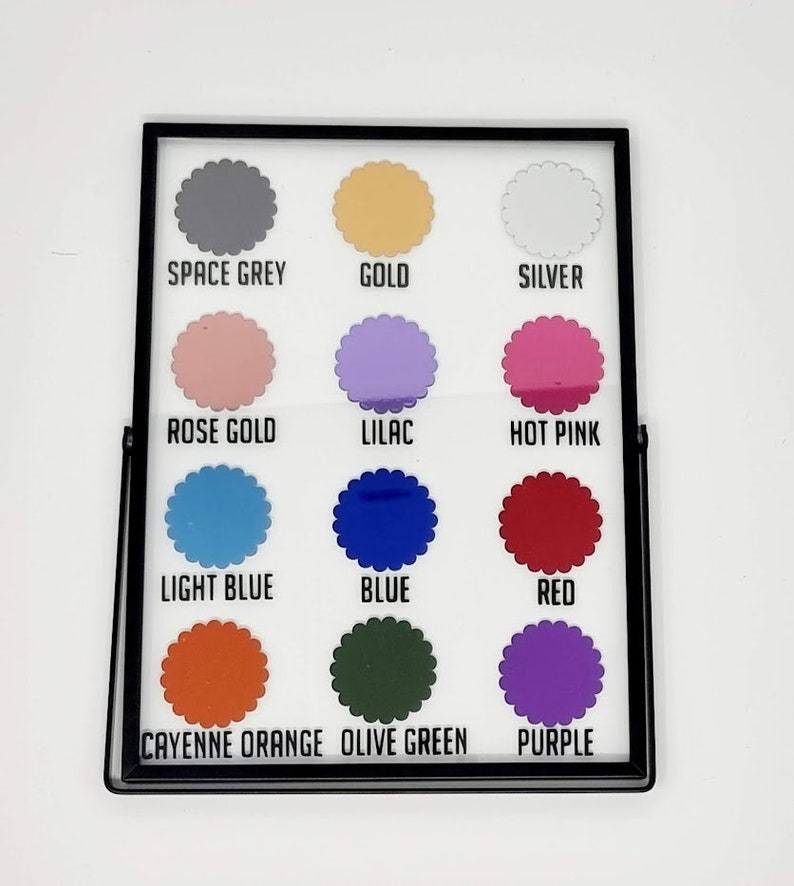 May include: A framed color chart featuring twelve different colors. The colors include space grey, gold, silver, rose gold, lilac, hot pink, light blue, blue, red, cayenne orange, olive green, and purple. Each color is labeled with its name.