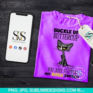 Könnte beinhalten: Ein lila T-Shirt mit dem Text "BUCKLE UP BUTTERCUP YOU JUST FLIPPED MY BITCH SWITCH" und einer Cartoon-Katzen-Illustration. Ein Smartphone und ein Etikett mit Logo sind ebenfalls sichtbar.
