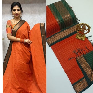May include: Orange and green checkered cotton saree with a gold and black border. The saree has a traditional design and is perfect for special occasions.