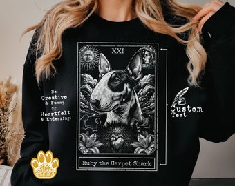 Puede incluir: Sudadera negra con un gráfico blanco de un perro en un diseño de estilo de carta de tarot. La carta dice "XXI" y "Ruby the Carpet Shark". El texto "Be Creative & Funny or Heartfelt & Endearing!" está en el lado izquierdo del gráfico. El texto "Custom Text" está en el lado derecho del gráfico.