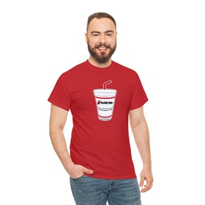 Puede incluir: Camiseta roja con un gráfico de un vaso de refresco y una pajita. El diseño del vaso incluye el texto "BLAZE ON" y "Premium Outdoor Soda" con texto adicional. La camiseta es de color rojo liso.