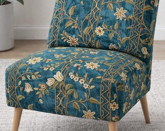 May include: A teal accent chair with a floral pattern. The chair features a low back, a square seat, and four wooden legs. The floral pattern includes cream-colored flowers and green leaves with gold-colored stems.