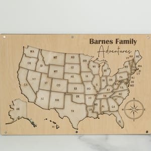 Może przedstawiać: Drewniana mapa Stan&oacute;w Zjednoczonych z konturami stan&oacute;w i r&oacute;żą wiatr&oacute;w. Tekst "Barnes Family Adventures" znajduje się nad mapą. Mapa jest wykonana z jasnego drewna i ma prostokątny kształt.