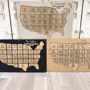 May include: Three wooden stadium tour maps in the shape of the United States. The top map is beige with the text "The Salasznyk's NFL Stadium Tour". The other two maps are black and light brown with the text "The Fuller's Football Stadium Tour" and "Carl's Football Stadium Tour".