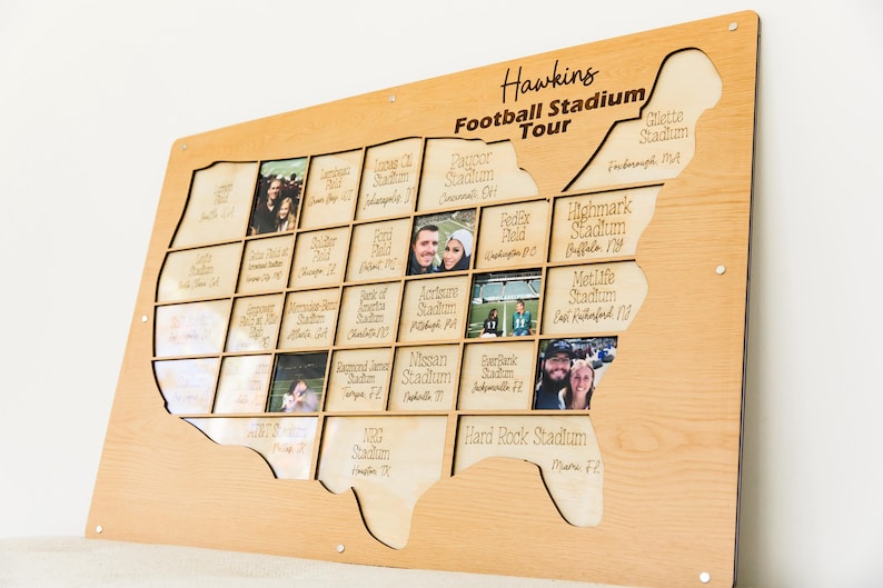 May include: A wooden map of the United States with cutouts for photos, labeled "Hawkins Football Stadium Tour." Each cutout is labeled with a stadium name and city. Photos are inserted into the cutouts.