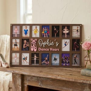 May include: A rectangular dark brown wooden photo collage frame featuring eighteen vertical slots for pictures. The center displays a pink wooden ballet slipper icon and the white and pink text "Ophie's Dance Years" in a script and block font.