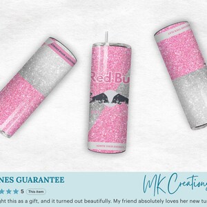 May include: Three glitter-covered tumblers with a pink and silver design. The central tumbler features the Red Bull logo and two black bulls. The other two tumblers have the text "NAUGHTY BITCH ENERGY" and "LEAVE YOUR MARK".