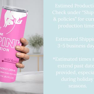 May include: A pink Red Bull tumbler with the text "THE PINK EDITION" and "Wild Berries." The tumbler has a silver lid and features the Red Bull logo. It contains 250 mL (8.4 FL OZ) of energy drink.