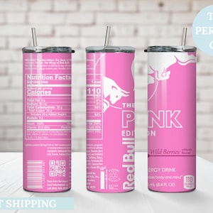 May include: Pink stainless steel tumbler with a straw, featuring the Red Bull logo and "The Pink Edition" text. The tumbler includes nutrition facts and "Wild Berries" flavor information. The text "The Perfect Gift" is also visible.