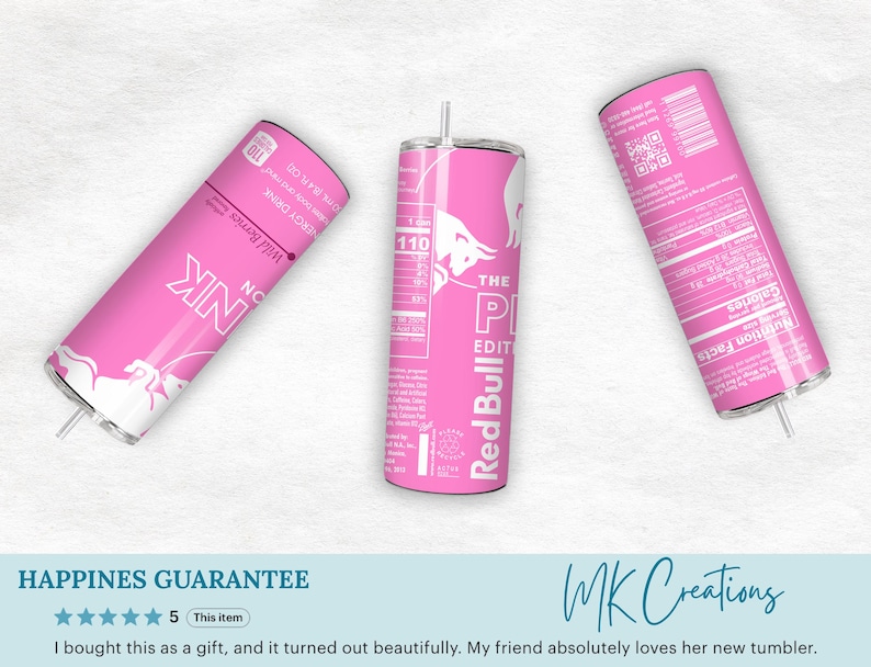 May include: Three pink Red Bull tumblers are displayed against a white background. The tumblers feature the Red Bull logo and text, including "The Pink Edition" and "Wild Berries." Each tumbler has a straw and a nutrition facts label.