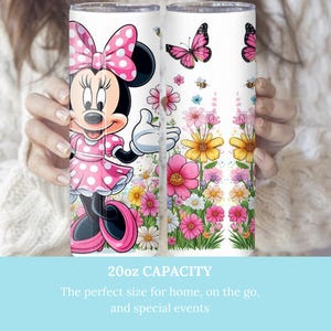 Puede incluir: Un vaso blanco de 20 oz con un dise&ntilde;o floral rosa y blanco. El vaso presenta una imagen de dibujos animados de Minnie Mouse con un vestido de lunares rosas y un lazo rosa. El texto "20oz CAPACITY" est&aacute; impreso en el vaso.