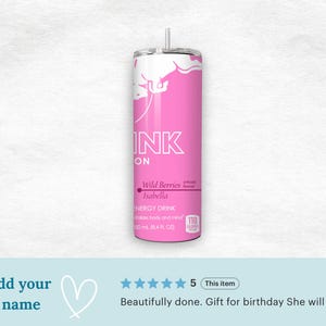 May include: A pink and white tumbler with a straw. The tumbler has the word "INK" in large white letters, and the words "Wild Berries Isabella" are printed below. The tumbler is designed to hold 50 ml (16.9 fl oz) of liquid.