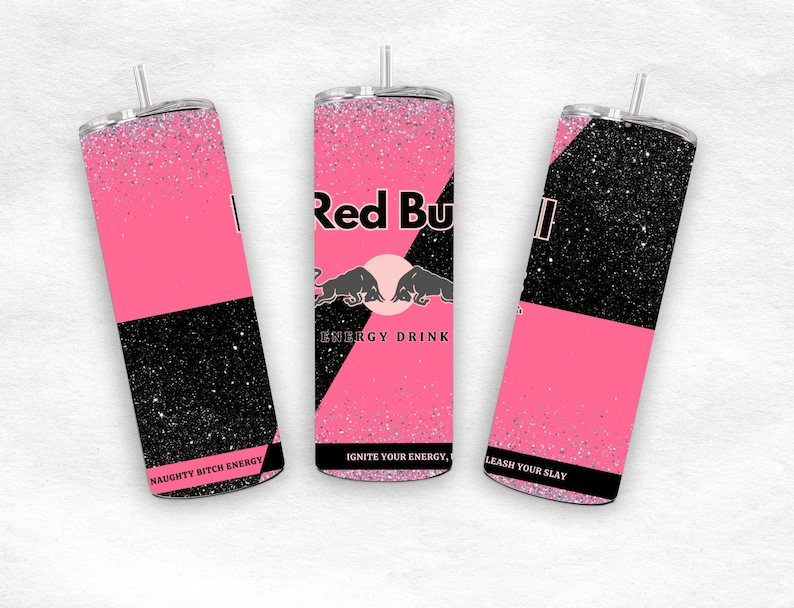 May include: Three pink and black glitter tumblers with a silver straw. The tumblers feature the Red Bull logo and the phrases "NAUGHTY BITCH ENERGY", "IGNITE YOUR ENERGY", and "LEASH YOUR SLAY".