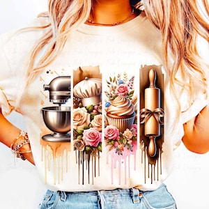 May include: A white t-shirt with a graphic design of a kitchen mixer, a chef's hat, a cupcake, and a rolling pin. The graphic is surrounded by floral designs and dripping paint.