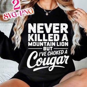 Op de afbeelding: Zwart sweatshirt met witte tekst die "Never killed a mountain lion but I've choked a Cougar" zegt.