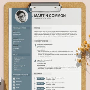 May include: A resume template on a brown clipboard featuring a blue sidebar with a circular headshot of a person wearing glasses, sections for personal details, skills, and hobbies, and a white main column for profile, work experience, and education.