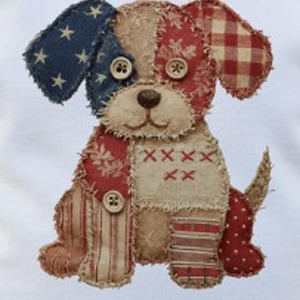 May include: A handcrafted fabric dog with patriotic colors. The dog has one blue ear with white stars, a red and white plaid ear, and a red and white floral patterned body. The dog is embellished with button eyes and decorative stitching.