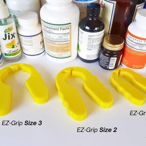 May include: Three yellow plastic EZ-Grip jar openers in different sizes. The largest EZ-Grip is labeled "EZ-Grip Size 3", the middle size is labeled "EZ-Grip Size 2", and the smallest is labeled "EZ-Grip Size 1".