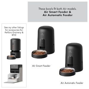 Op de afbeelding: Zwarte voerautomaten voor huisdieren met roestvrijstalen kommen gevuld met dierenvoeding. De afbeelding bevat de tekst "Air Smart Feeder" en "Air Automatic Feeder". De tekst bovenaan luidt "Deze kommen passen op beide Air-modellen."