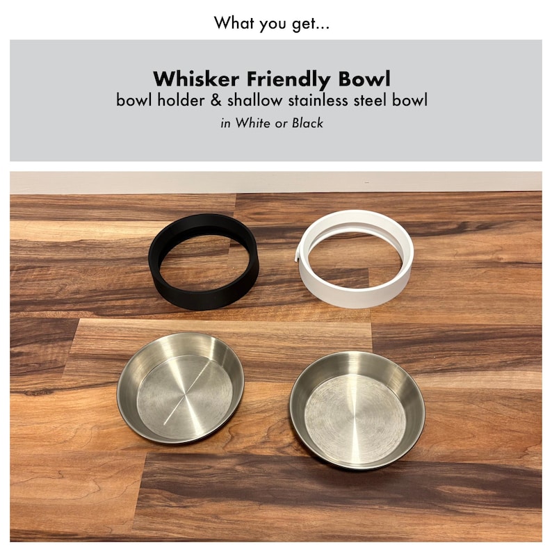 Op de afbeelding: Een huisdierenset met een zwarte en een witte komhouder en twee ondiepe roestvrijstalen kommen. De tekst luidt "Whisker Friendly Bowl" en "bowl holder & shallow stainless steel bowl in White or Black."
