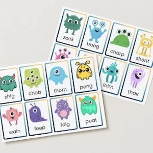 May include: Two sets of flashcards featuring colorful cartoon monsters. Each card has a unique monster illustration and a corresponding word. The cards are white with blue borders and are designed for educational purposes.