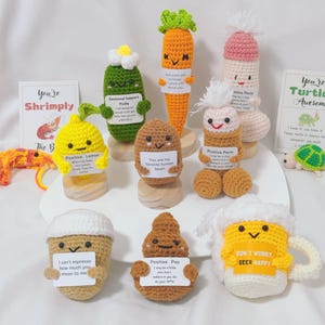 Pode incluir: Uma coleção de figuras de crochê caprichosas, incluindo um limão, uma cenoura e um caneco de cerveja, cada uma com um rosto sorridente e um pequeno letreiro. As figuras são em várias cores, como amarelo, laranja e castanho. Alguns letreiros têm textos como "Positive Lemon" e "Don't Worry Beer Happy."