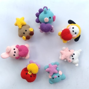 Peut inclure: Une collection de neuf jouets en peluche crochetés de différentes couleurs et formes, dont une étoile, un cœur, un dinosaure, un lapin et un chien. Les jouets sont tous faits à la main et ont une texture douce et câline.