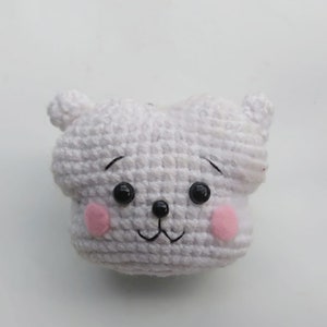 May include: White crocheted stuffed animal with black eyes, a black nose, and pink cheeks.