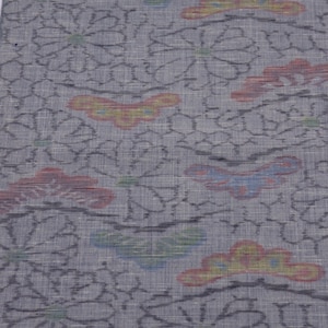 Könnte beinhalten: Ein grauer Stoff mit einem gewebten Muster aus Blumen und Schmetterlingen. Der Stoff hat einen dezenten Glanz und eine weiche Textur. Die Schmetterlinge sind in Rot-, Gelb-, Blau- und Grüntönen gehalten.