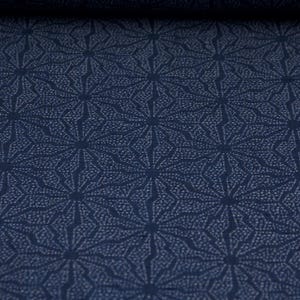 Op de afbeelding: Een donkerblauwe stof met een wit geometrisch patroon van herhalende sterren.